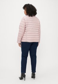Svetloružový puffový kabát s horizontálnym šitím a okrúhlym výstrihom. V kombinácii s tmavomodrými džínsami a čiernymi lodičkami.