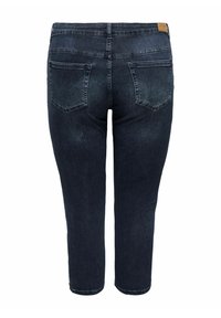 Dark blue denim jeans with a fitted design, featuring two back pockets and a leather label at the waistband. Smooth texture and mid-rise fit.