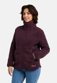 Veste en polaire de couleur violet foncé avec un col haut, fermeture éclair à l'avant, poches latérales et détail de logo. Tissu texturé et chaud, coupe décontractée.