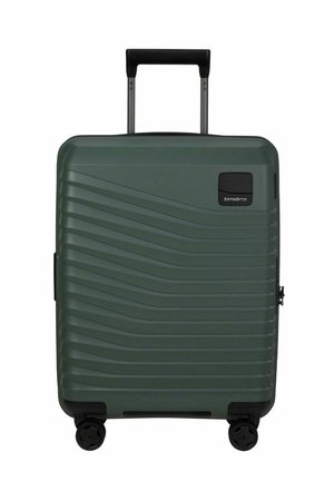 Valise rigide vert foncé avec poignée télescopique, quatre roues pivotantes et des rainures horizontales à motif ondulé.