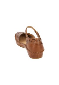 Sandale en cuir tan avec un design floral découpé, une sangle à la cheville et des détails tressés le long de la semelle. Forme arrondie et talon bas.