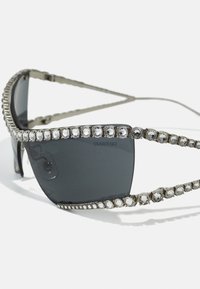 Silmad musta raami, kaunistatud selgete Swarovski kristallidega üleval ja külgedel, tumepruunid läätsed.