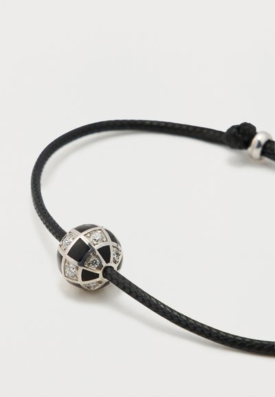 Čierny náramok z opleteného šnúrového materiálu s okrúhlym korálikom s lesklým čiernym povrchom a striebornými akcentmi, osadený malými priezračnými kamienkami.