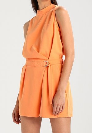 Combinaison sans manches orange avec un col montant, taille cintrée mettant en valeur une boucle en argent, et un tissu drapé créant une texture lisse.