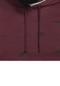 Maroon hoodie with a textured finish, featuring black Nike logos and "Nike Inc." printed throughout. Includes matching drawstrings.