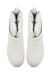 Bijele sintetičke čizme s podstavljenim ovratnikom, kviltanom teksturom i petljama za povlačenje. Zaobljen djever i podložni potplati za udobnost.