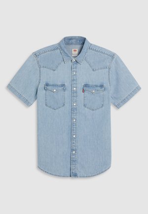 Svetlo modrá krátkorukávová rifľová košeľa so špicatým sedlom, dvoma náprsnými vreckami a perlovo zapínacími gombíkmi. Mäkká textúra a ležérny strih.