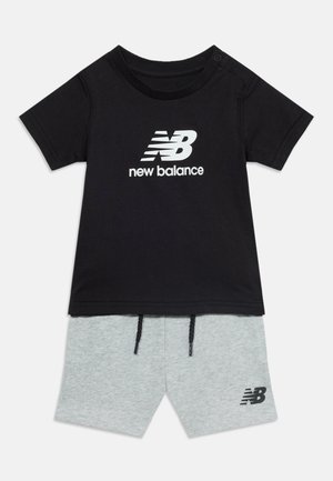 T-shirt nera a maniche corte New Balance con logo bianco abbinata a pantaloncini grigio chiaro con coulisse, con un piccolo logo New Balance nero.
