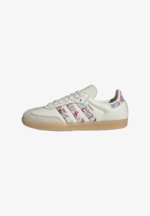 Baskets Adidas Samba blanches avec des bandes et un renfort de talon à motif floral, semelle en gomme et bout en daim.