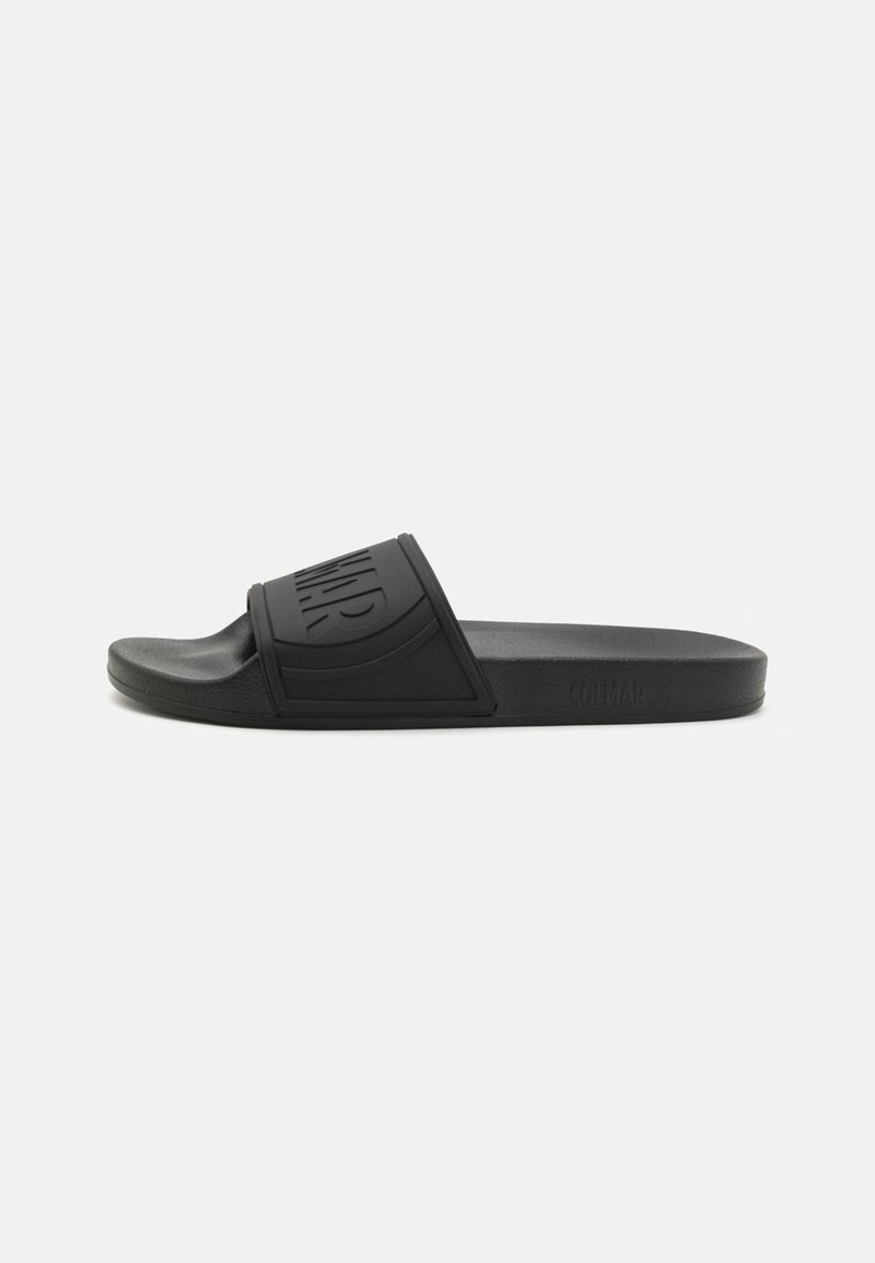 Black silicone slide sandal with a wide strap featuring a raised logo, textured footbed, and flat outsole. Minimalistic design without embellishments.