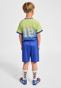 Kortärmad sporttröja i gradient från grön till blå med nummer 12, tillsammans med blå shorts och vita strumpor med svarta chevronränder.