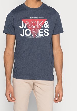 T-shirt bleu marine en coton doux, ornée d'un imprimé graphique audacieux en blanc et rouge avec le texte "JACK & JONES" et un motif triangulaire.