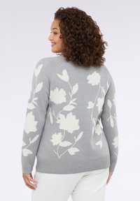 Světle šedý svetr s květinovým bílým vzorem, žebrovanými manžetami a uvolněným střihem, který se vyznačuje měkkou texturou a kulatým výstřihem.