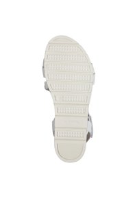 Vit syntetisk sandal sula med texturerad sula, som har ett mönster av triangulära och horisontella spår för grepp och stabilitet.