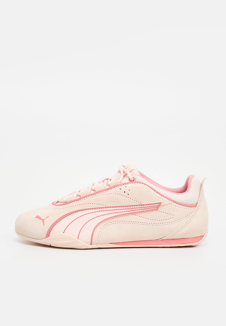 Lichtroze suede sportieve schoen met roze accenten, structurele bovenkant, vetersluiting, flexibele zool en handtekeninglogo aan de zijkant.