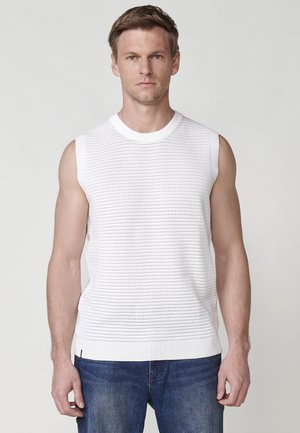 Top alb fără mâneci, tricotat, cu un model texturat, guler rotund cu dungi și tiv, asortat cu blugi din denim albastru cu o croială casual.