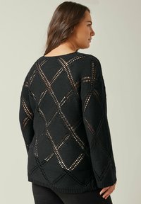 Schwarzer gestrickter Pullover mit offenem Rautenmuster, strukturiertem Stoff, langen Ärmeln und legerer Passform mit geripptem Saum.