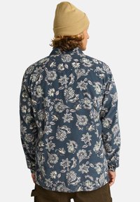 Bloemmotief, lange mouw shirt van donkerblauwe stof, met lichtgroene en roze ontwerpen, voorzien van een knoopsluiting kraag en een ontspannen pasvorm.