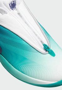 But z gradientowym wzorem w odcieniach teal i białym, z zamkiem błyskawicznym oraz teksturowaną cholewką. Zawiera perforacje dla lepszej wentylacji.