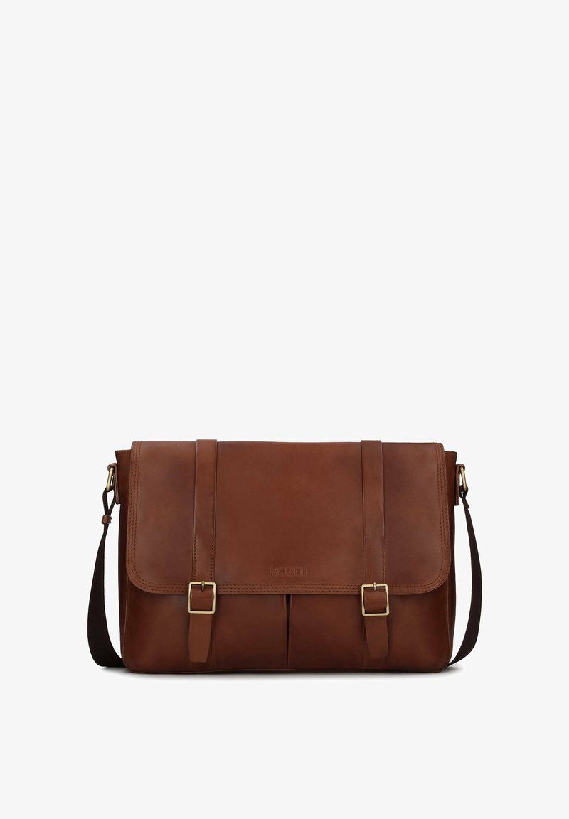 Borsa a tracolla in pelle marrone con due fibbie frontali, tracolla regolabile e chiusura a patta. Texture liscia, design strutturato.