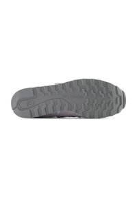 Suola di sneaker grigia con scanalature profonde e texture per una maggiore aderenza. Presenta il logo "New Balance" inciso vicino al tallone. Design con punta arrotondata.