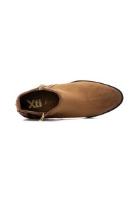 Stivaletto in suede marrone con punta affusolata, dettagli in zip dorati e suola nera testurizzata. L'interno presenta il logo del brand.