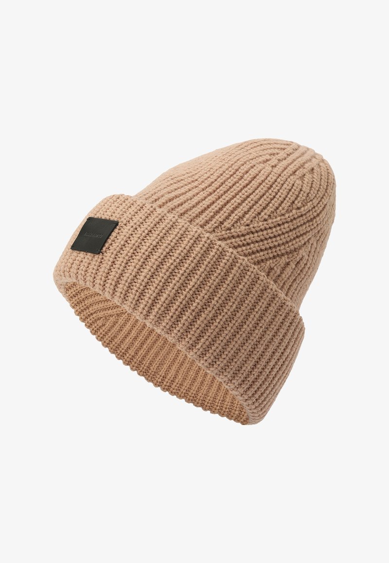 Vaaleanbeige neulepipo, jossa on ribbikuvio ja käännettävä reunus. Reunuksessa on musta neliön muotoinen etiketti. Pehmeää, joustavaa materiaalia.