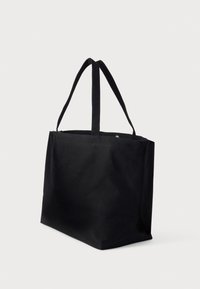Czarna torba na ramię z płótna, z dwoma długimi uchwytami, prostokątnym kształcie, gładką fakturą, bez widocznych logo ani wzorów.