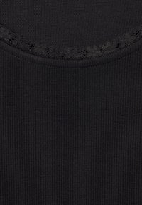 Tejido de canalé negro con un escote redondo, que cuenta con un delicado borde de encaje. Textura suave, material ligero.