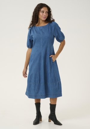 Jeansklänning med korta, puffärmar, fyrkantig halsringning, sidofickor och veckade detaljer vid fållen. Buren med svarta ankelboots.