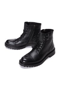 Botas de cuero negro con un acabado texturizado, punta redonda y suela de goma. Presenta cierre de cremallera y diseño con cordones con ojales de metal.