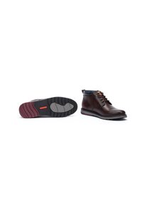 Brown leather ankle boots with black accents, rounded toe, and lace-up design. Features a textured black and maroon sole with traction patterns.