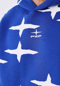 Sudadera azul con grandes patrones de estrellas blancas, tejido texturizado y un pequeño logo "PXP" bordado en blanco. Incluye capucha con cordón.