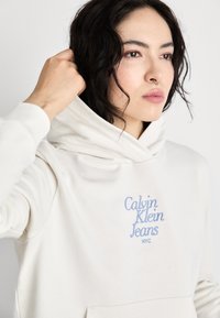 Calvin Klein Jeans FONT GRAPHIC REGULAR HOODIE - Športni pulover - ivory