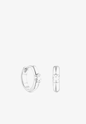 Pendientes de aro de plata con un diseño de oso en la parte frontal. Superficie lisa y pulida con forma redondeada y un mecanismo de cierre simple.