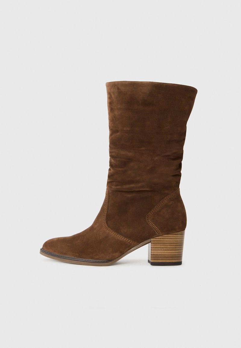 Rudos einuminiu odiniai auliniai batai iki blauzdos su apvalia nosimi ir mediniu blokiniu kulnu ant balto fono.