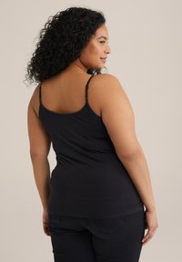 Schwarzes ärmelloses Tanktop mit dünnen Trägern, aus weichem Baumwollmaterial gefertigt. Eng anliegendes Design mit glatter Textur und ohne sichtbare Muster oder Verzierungen.