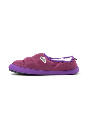 Zapatilla de interior morada acolchada con suela texturizada y forro interior blanco suave, que muestra un logo "nubia" en el lateral.