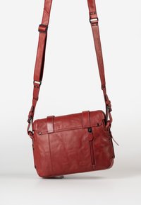 Borsa a tracolla in pelle rossa con tracolla regolabile, tasca con zip e finitura testurizzata. Presenta hardware nero e rifiniture cucite.