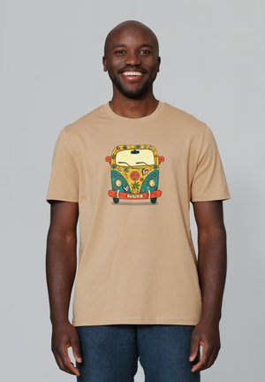 Beige katoen t-shirt met een kleurrijke voorprint van een vintage bus omringd door bloemen en vredessymbolen. Korte mouwen, ronde hals.