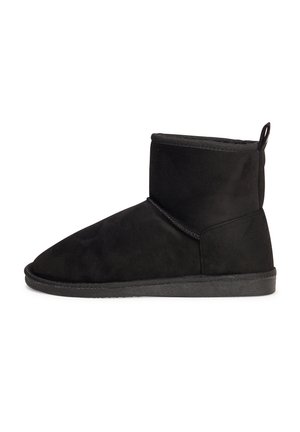 Botte de cheville en cuir suédé noir avec un bout rond, texture lisse et semelle en caoutchouc plate. Elle présente une languette à l'arrière et des détails de couture minimalistes.