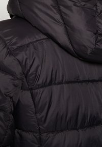 Svart puffjacka med huva, med quiltade sektioner och en slät, glansig yta som framhäver dess isolerande design.