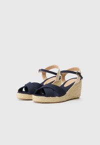 Marina tygklädda kilklackssandaler med tvärribbad rem, espadrilles-stil jutesulor och ankelspänne. Öppen tå-design förbättrar andningsförmågan.