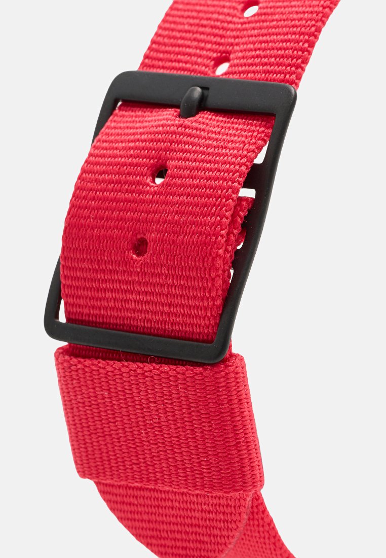 Cinturón de tela tejido en rojo con hebilla cuadrada negra y múltiples agujeros de ajuste sobre un fondo blanco.