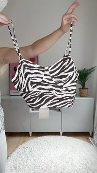 Top s uzorkom zebre u smešnoj i beloj boji, s tankim trakama, strukturiranim oblikom, teksturiranim materijalom i naborima na prednjoj strani.