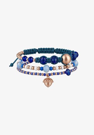 Bracelet à trois couches avec perles bleues et blanches, cordon tressé bleu marine, accents en or rose et un charm gland en or rose.