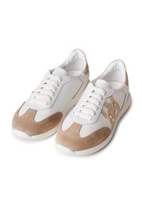 Des baskets blanches et beiges en cuir et daim, avec un bout rond, un design à lacets et des accents décoratifs sur les côtés.