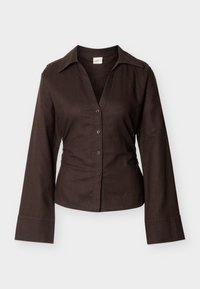 Σκούρο καφέ πουκάμισο με μακριά μανίκια και κουμπιά, με φαρδιά γιακά και εφαρμοστή μέση, εμφανίζεται σε λευκό φόντο.