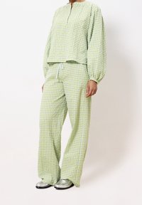 Zelené kostkované loungewear set s volným dlouhým rukávem a kalhotami širokého střihu, vyrobený z lehké strukturované látky.