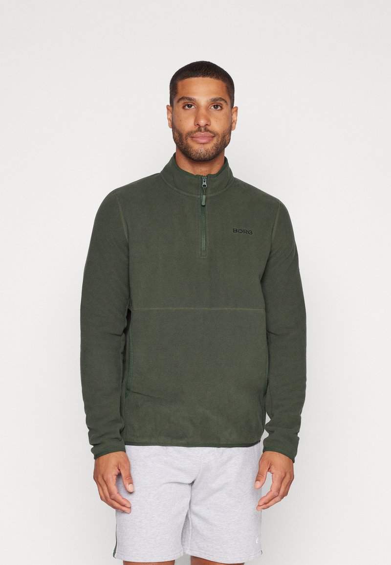 Giacca in pile verde con design a mezzo zip, caratterizzata da un colletto alto e un discreto dettaglio del logo sul petto. Morbida al tatto e con vestibilità casual.